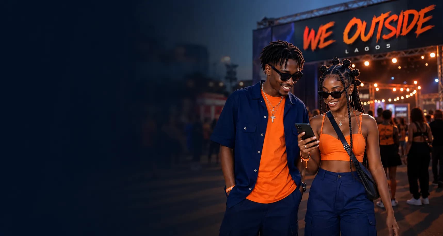 Young attendees checking their phone at an outdoor event in Lagos.